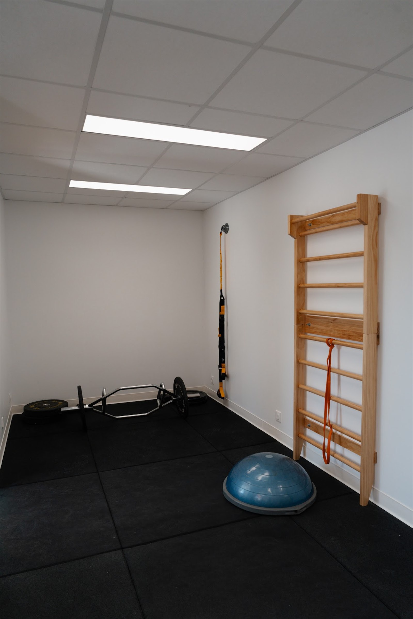 Seconde salle : espace de travail au sol avec espalier et bosu